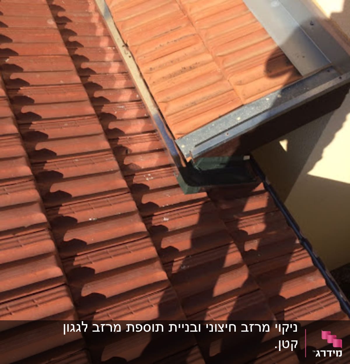 רעפים חומים על גג עם תעלת ניקוז מתכתית